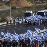 Des milliers de manifestants, selon les médias, se sont rassemblés à l'aéroport Ben Gourion de Tel-Aviv, agitant des drapeaux israéliens blanc et bleu, klaxonnant et criant des slogans hostiles à la réforme.